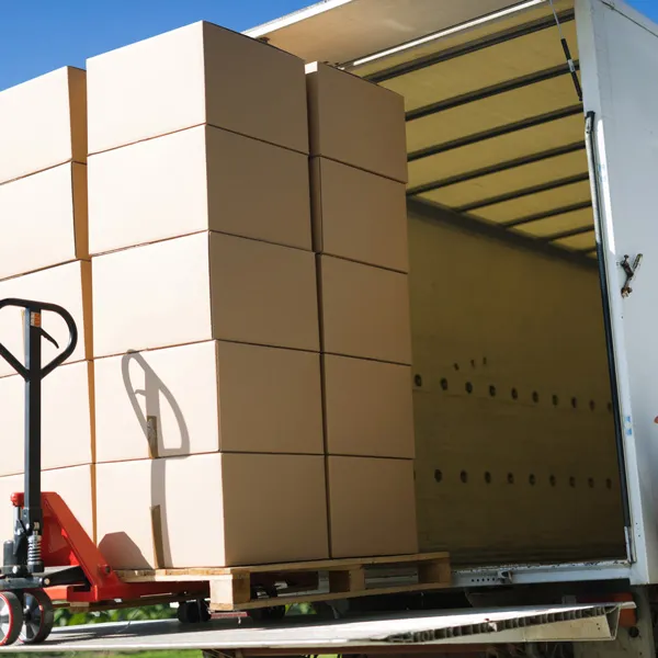 Chargement palettisé de cartons à l’intérieur d’une semi-remorque, avec un transpalette